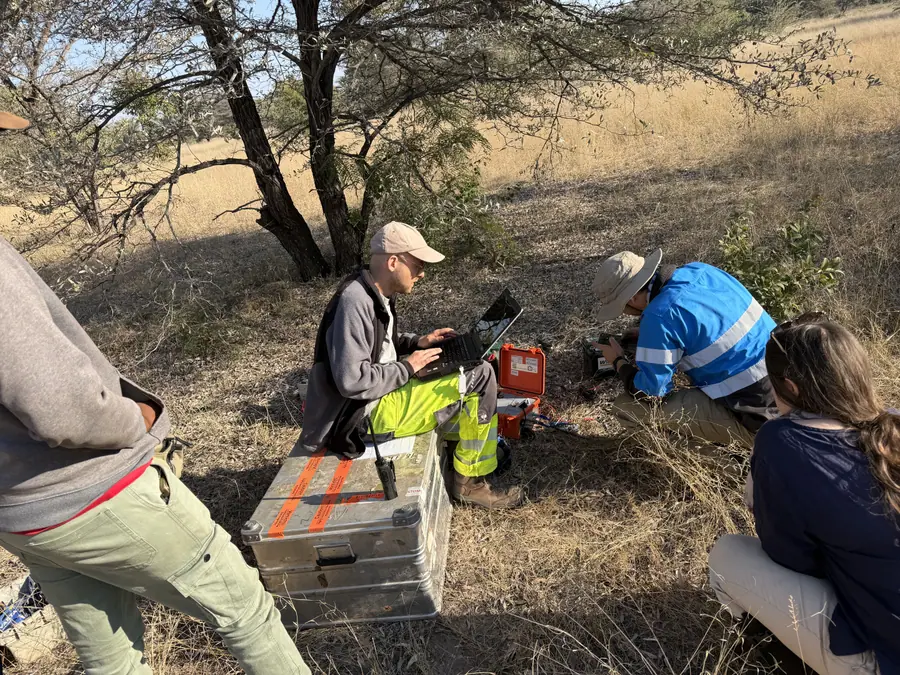 Survey team reviewing geophysical data on site in Mwandi, Southern Province, Zambia